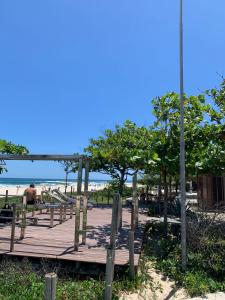 a wooden boardwalk on the beach with the ocean in the background at Duplex em Itaúna 4min da Praia que ocorre o WSL, 1min da pista de skate do LS, pracinha com parque infantil, quadra de futebol, tudo isso a 1 min da duplex, perto do comércio, wi-fi super rápido, monitoramento 24hrs in Saquarema