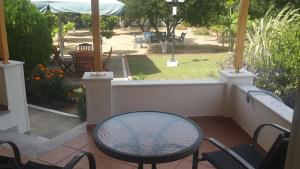 a patio with a table and chairs and a yard at Elisabeth Villas in Kerveli