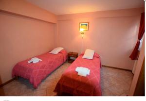 een hotelkamer met twee bedden met handdoeken erop bij Hosteria Ailen in Ushuaia