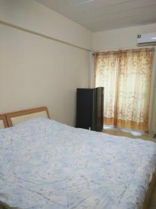 a bedroom with a bed and a television and a window at The Prince Residence , Weekly Stay Chiang Rai in Chiang Rai