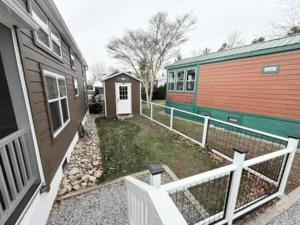 a home with a fence next to a house at Cozy 1BR Tiny Home with Pool Access and Free Tix in Flat Rock