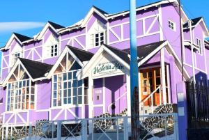 een roze en wit gebouw met een blauwe paal bij Hosteria Ailen in Ushuaia
