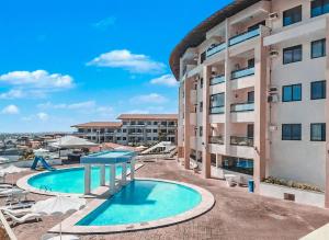 Studio no Porto das Dunas vista mar e Beach Park! في Mangabeira: مبنى كبير مع مسبح بجانب مبنى +6 صور