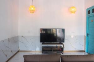 a living room with a couch and a flat screen tv at Filladhoo inn in Filadu