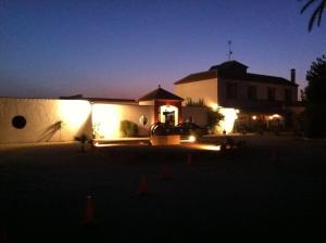 a house with lights on the side of it at night at Molino La Boticaria in Marchena