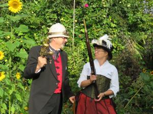 un hombre y una mujer vestidos con trajes parados en un jardín en Merrybrook Studio en Oamaru