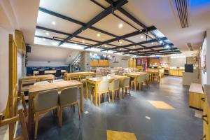 ein Speisesaal mit Tischen und Stühlen in einem Restaurant in der Unterkunft Starway Hotel Chongqing Nanbin Road Riverview in Chongqing