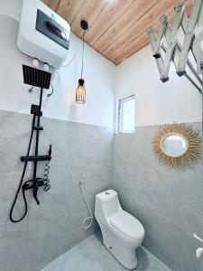 ein Badezimmer mit Toilette und einer Kamera auf einem Stativ in der Unterkunft Arutala Villa 4-7 Lautan Awan in Diyeng