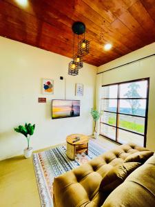 ein Wohnzimmer mit Sofa und Tisch in der Unterkunft Arutala Villa 4-7 Lautan Awan in Diyeng