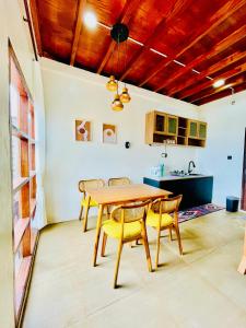 ein Esszimmer mit einem Holztisch und Stühlen in der Unterkunft Arutala Villa 4-7 Lautan Awan in Diyeng