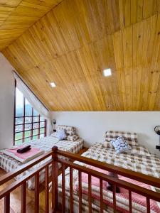 2 Betten in einem Zimmer mit Holzdecke in der Unterkunft Arutala Villa 4-7 Lautan Awan in Diyeng + 34 Fotos
