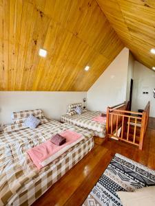 zwei Betten in einem Zimmer mit Holzdecken in der Unterkunft Arutala Villa 4-7 Lautan Awan in Diyeng