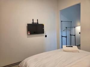 a room with a bed with a tv on the wall at Nido Nomad Lodge in Tamparuli