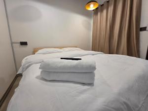 a pile of towels sitting on top of a bed at Nido Nomad Lodge in Tamparuli