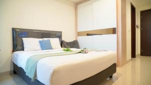 ジャカルタにあるSpacious and Homey Studio at Cleon Park Apartment By Travelioの部屋の中に大きなベッドがある寝室 +12枚の写真