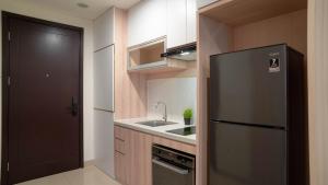 ジャカルタにあるSpacious and Homey Studio at Cleon Park Apartment By Travelioのステンレス製の冷蔵庫とシンクを備えたキッチン