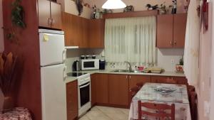 a kitchen with wooden cabinets and a white refrigerator at Elisabeth Villas in Kerveli