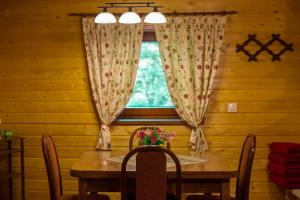 ein Esszimmer mit einem Tisch und einem Fenster in der Unterkunft Chata Alia in Vyšná Boca