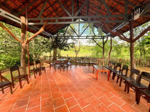 a group of tables and chairs under a pavilion at Nam Cat Tien Retreat in Tân Phú