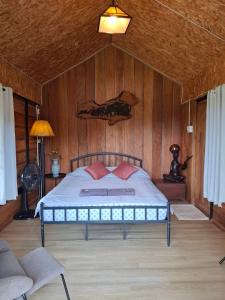 a bedroom with a bed with a wooden wall at Samatha Camper in Chiang Dao