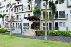 a building with palm trees in front of it at Mondavi II Condo Unit 306 in Silang