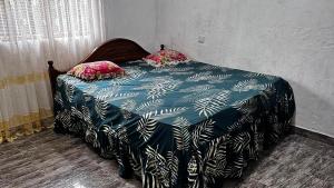 ein Bett mit einer blauen und weißen Bettdecke und zwei Kissen in der Unterkunft Ocean Whisper Guest House in Mirissa