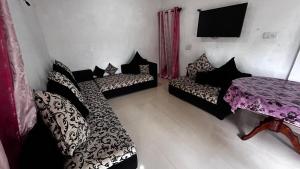 Zimmer mit 2 Betten, einem Tisch und einem TV in der Unterkunft Ocean Whisper Guest House in Mirissa