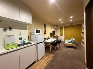 高山Vieuno Hida Takayama的厨房配有白色冰箱和桌子