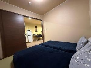 高山Vieuno Hida Takayama的一间带两张床的卧室和一扇通往厨房的门