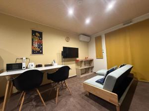 高山Vieuno Hida Takayama的带书桌和沙发的客厅 更多100张照片