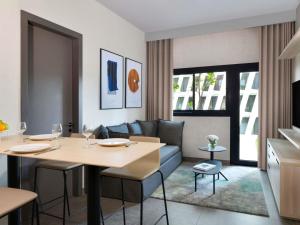 una sala de estar con una mesa y un sofá en Aparthotel Adagio Abidjan Marcory, en Abiyán