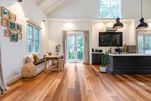 een grote woonkamer met houten vloeren en witte muren bij The Red Hill Barn in Main Ridge