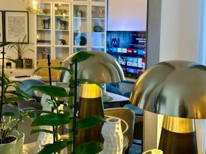 two silver lamps sitting on a table with plants at Apt Place de Toscane - 4min Disneyland-PARIS in Serris