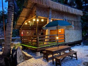 Alfonsa Tent Ground - Camp By The Sea في أوسلوب: طاولة مع مظلة أمام مبنى