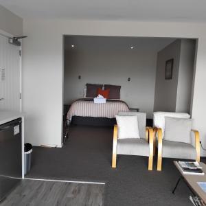 a bedroom with a bed and two chairs and a table at Lake Vista in Lake Tekapo