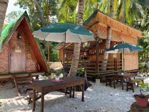 Alfonsa Tent Ground - Camp By The Sea في أوسلوب: منزل وطاولتين ومظلة