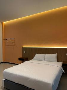 1 cama blanca grande en una habitación con pared en SM Guesthouse, en Blimbing