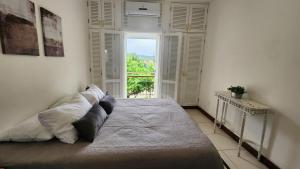 Duplex com Hidro em Condomínio Luxo com 3 Praias في انغرا دوس ريس: غرفة نوم بسرير كبير مع نافذة كبيرة +71 صورة