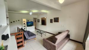 Duplex com Hidro em Condomínio Luxo com 3 Praias في انغرا دوس ريس: غرفة معيشة مع أريكتين وتلفزيون