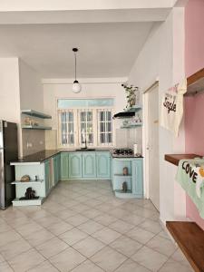 a kitchen with blue cabinets and a tile floor at Casa Carmen Hostel in Weligama