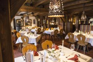 a restaurant with white tables and chairs and chandeliers at Wellnesshotel Bürgerstuben in Willingen