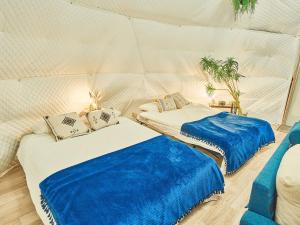 a room with two beds in a tent at リバーサイドグランピングNuts in Higashiomi