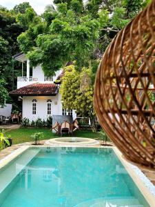 a swimming pool in front of a house at Casa Carmen Hostel in Weligama