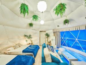 a room with two beds and potted plants on the ceilings at リバーサイドグランピングNuts in Higashiomi +81 photos