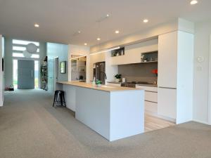 a kitchen with white cabinets and a white counter top at Hosts on the Coast Skippers Landing in Whitianga