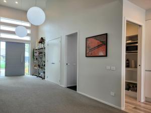 a hallway of a home with white walls at Hosts on the Coast Skippers Landing in Whitianga +6 photos