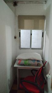 a small room with a bed and two windows at Casa cerca de la playa in La Paloma