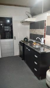 a kitchen with a sink and a stove top oven at Casa cerca de la playa in La Paloma