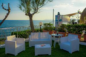 a patio with chairs and a table and the ocean at Holiday Village in Fondi