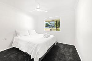 Poppi's Paradise - 5 Minutes Walk to the Beach في سانكشوري بوينت: غرفة نوم بسرير أبيض مع نافذة